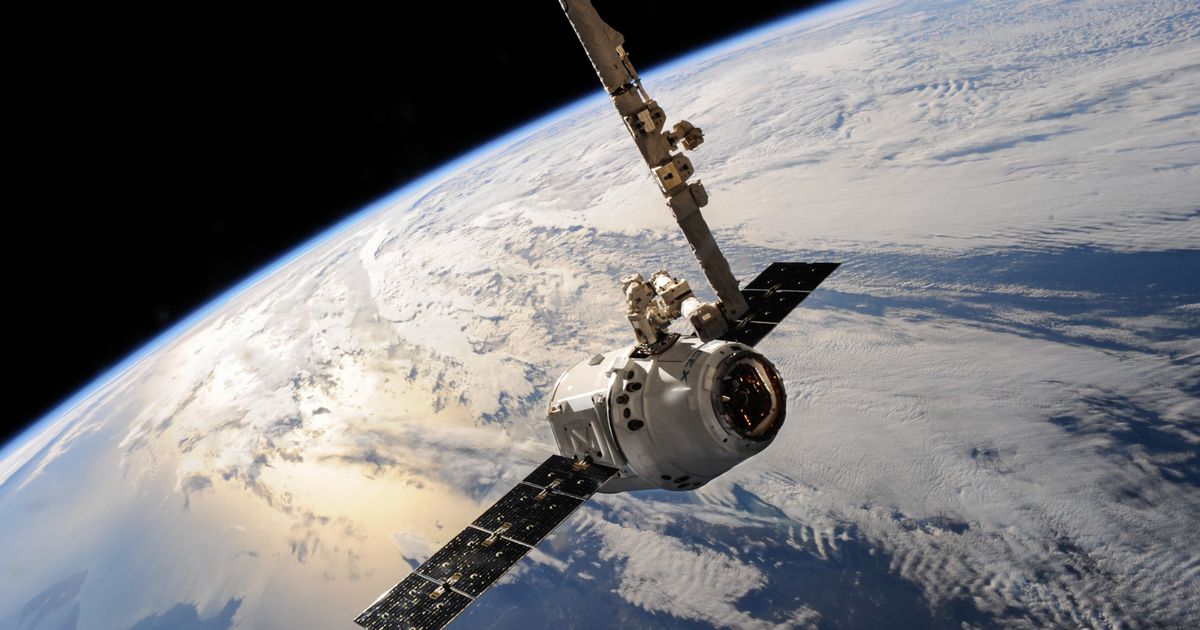 A white satellite in orbit above the Earth.