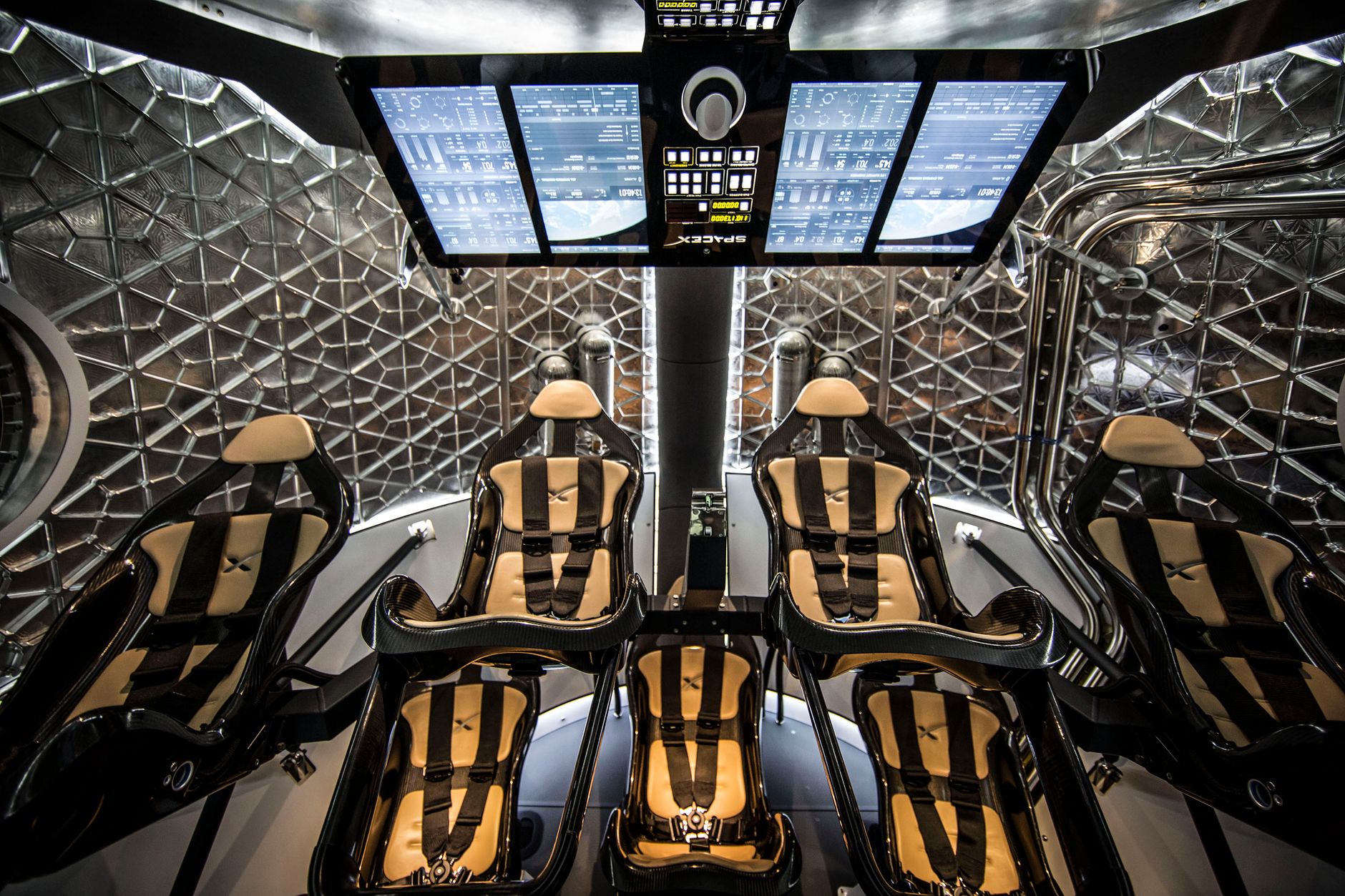 From below of modern interior of spacecraft capsule with seats and monitor panel for flight simulation
