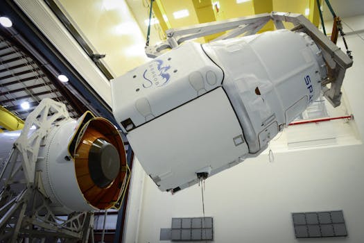 Close-up of a spacecraft being assembled and installed in an industrial facility.