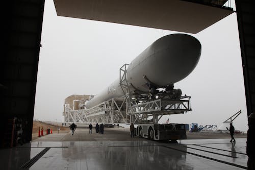New installed rocket booster placed on transporter platform and moving into vehicle assembly building in space center on cloudy day