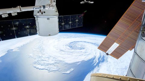 A mesmerizing view of Earth as seen from a space station with solar panels and satellite modules.