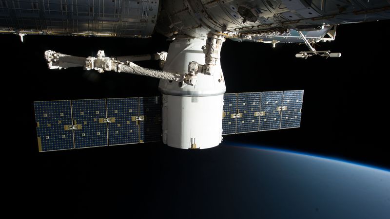 satellite with large solar arrays orbiting above Earth