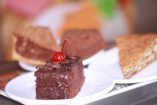 Close-up of a chocolate cake slice with cherry topping, perfect for dessert lovers.