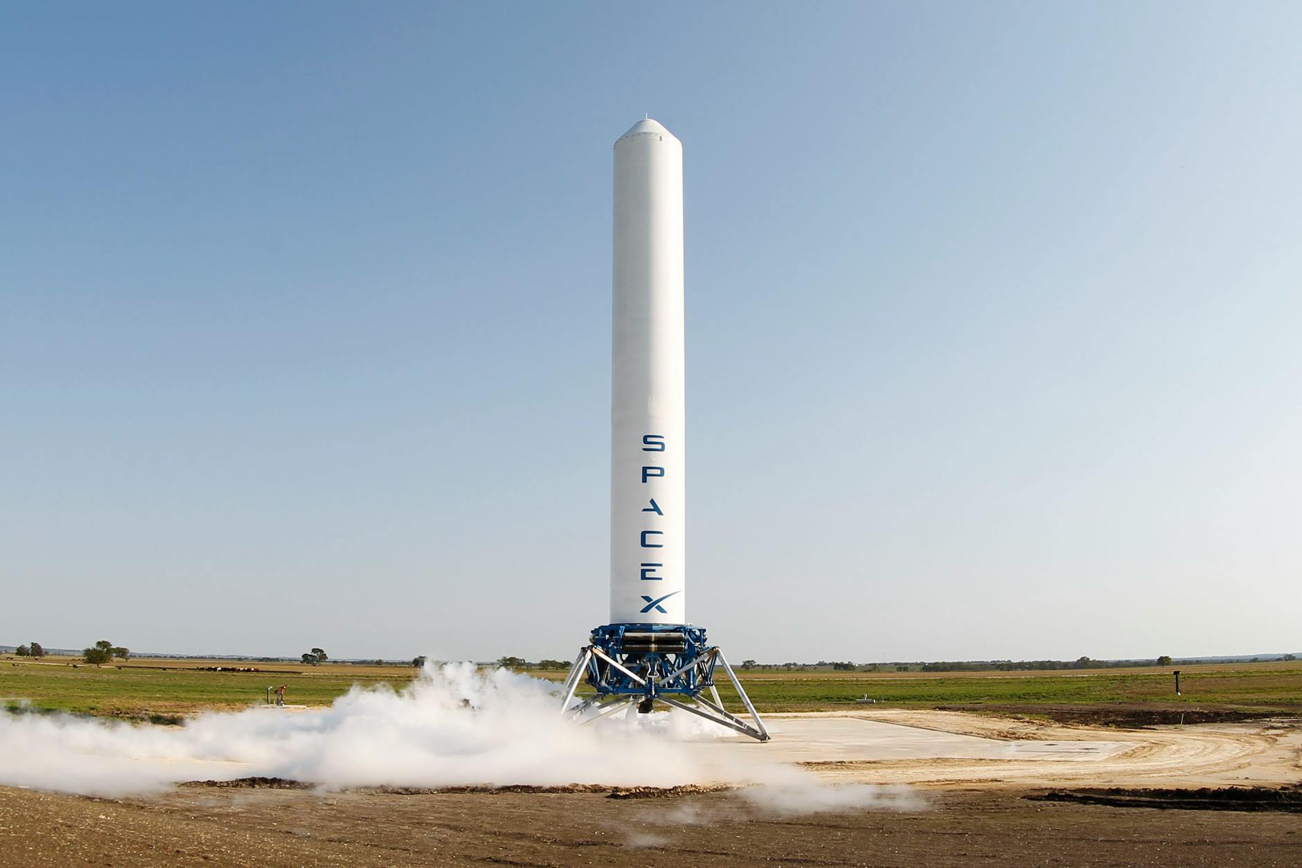 A SpaceX rocket prepares for launch in a rural landscape, capturing a sense of technological advancement.