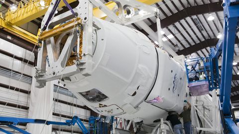 Low angle of unrecognizable technicians inspecting detail of new rocket booster at industrial space factory