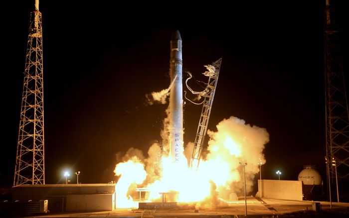 A rocket lifting off at night against a dark sky.