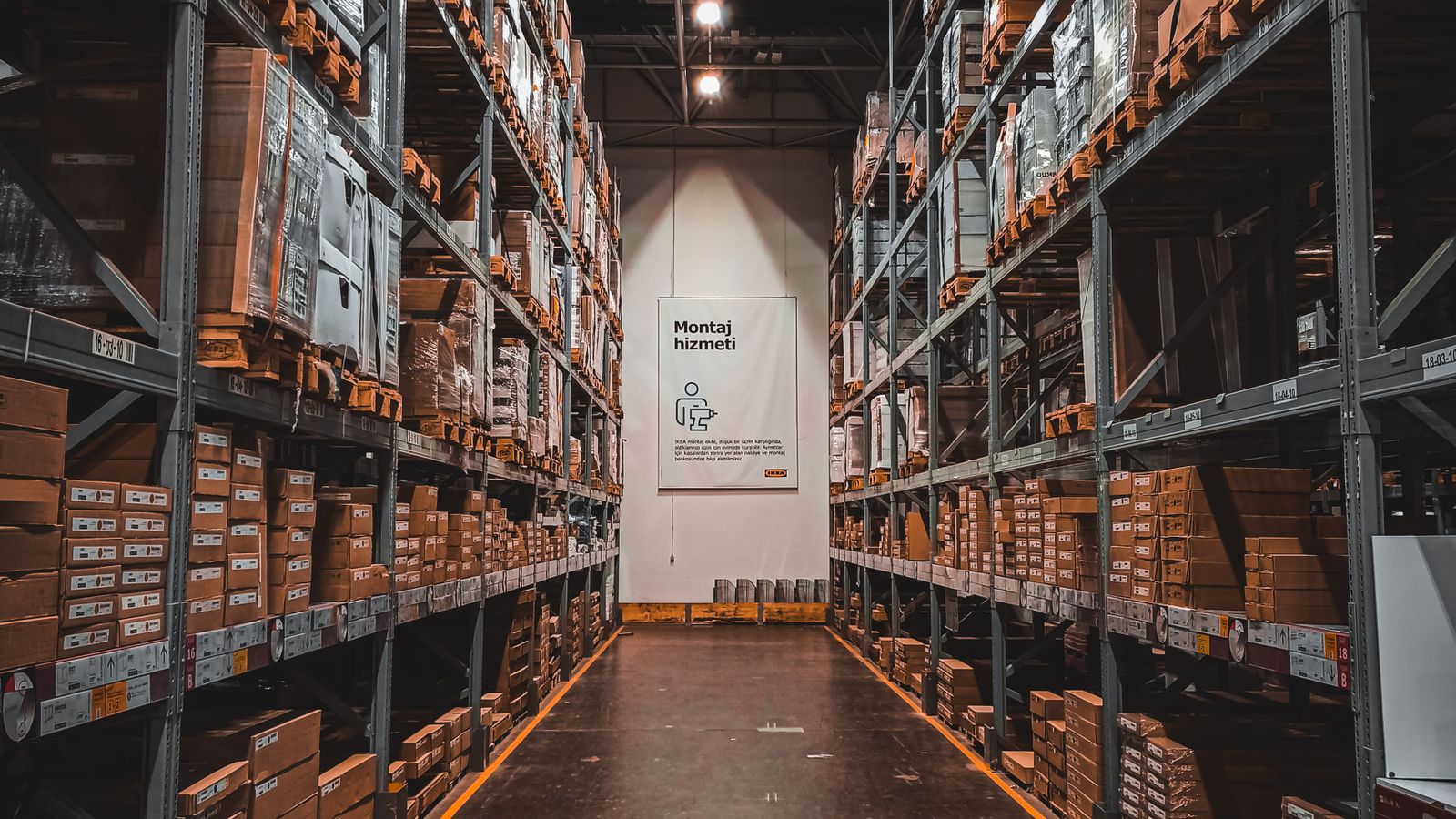 収納サービス企業の倉庫内を、整然と積まれた段ボール箱や荷物とともに写したイメージ