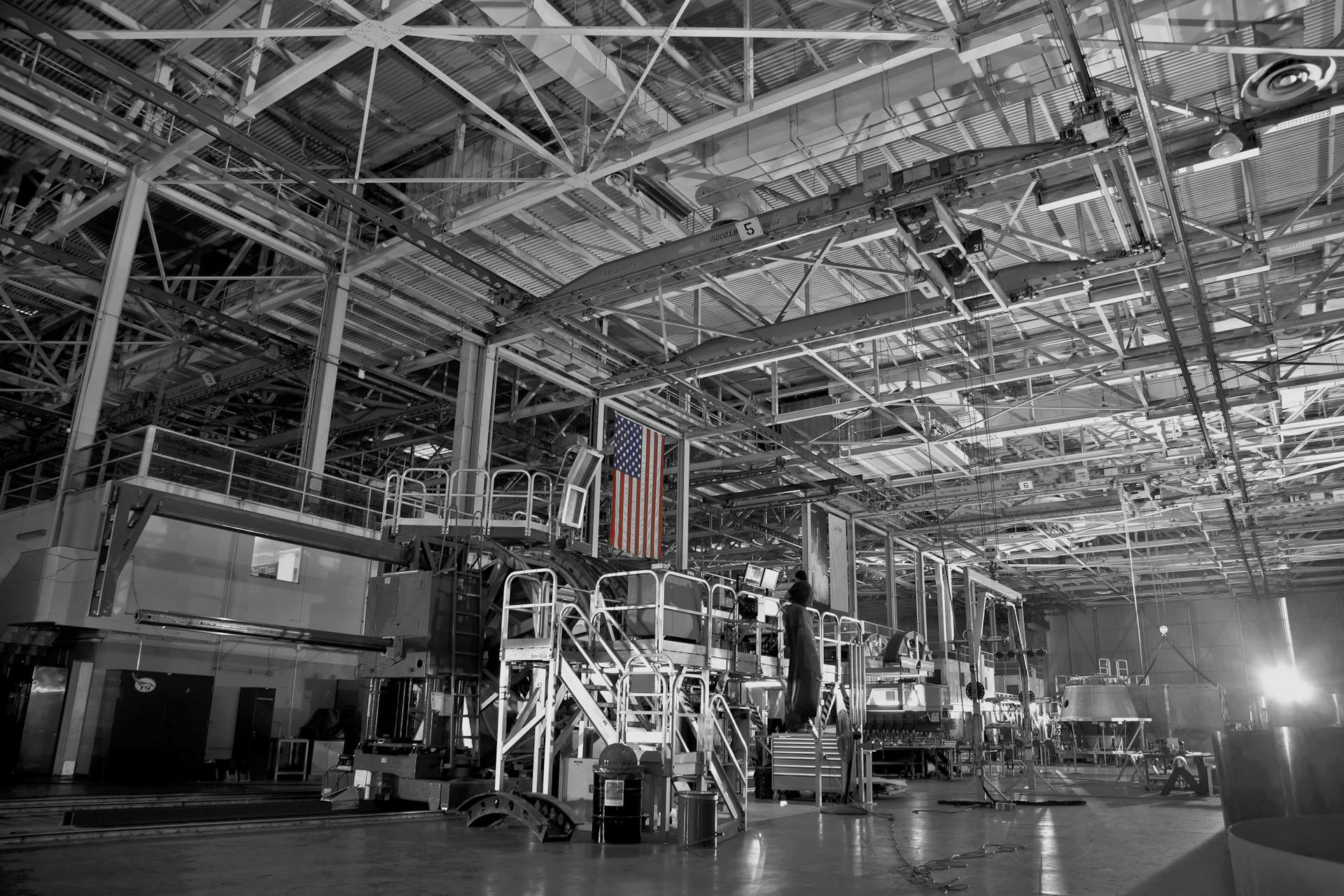 Black and white photo of an expansive industrial facility with American flag hanging prominently.