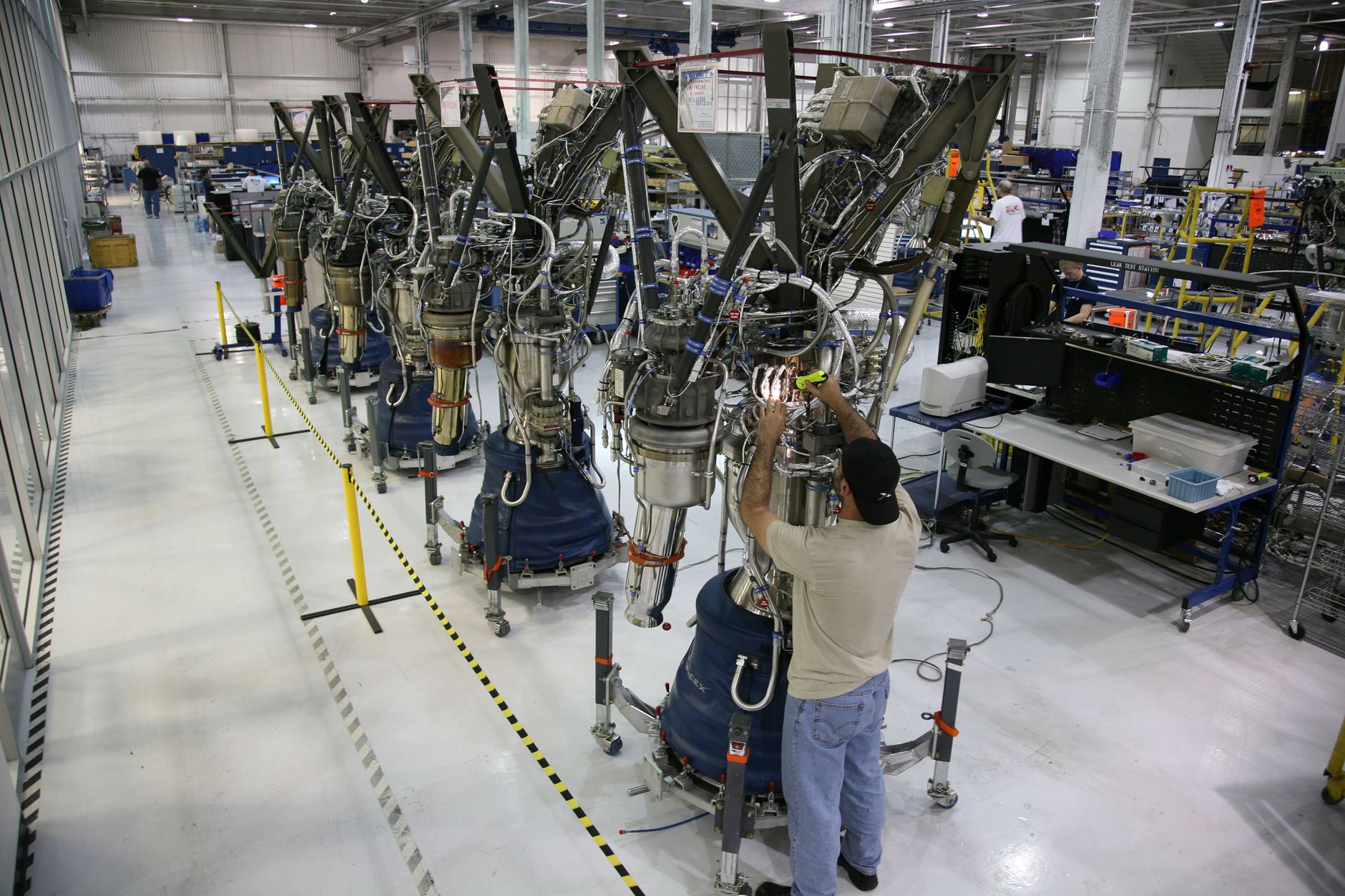 Technician inspecting spacecraft hardware in an assembly facility, mirroring the execution and capital demands behind Rocket Lab's Neutron build-out.