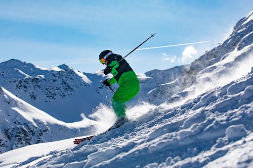 Free Skier in vibrant green outfit carving through snowy slopes in Vorarlberg, Austria. Stock Photo