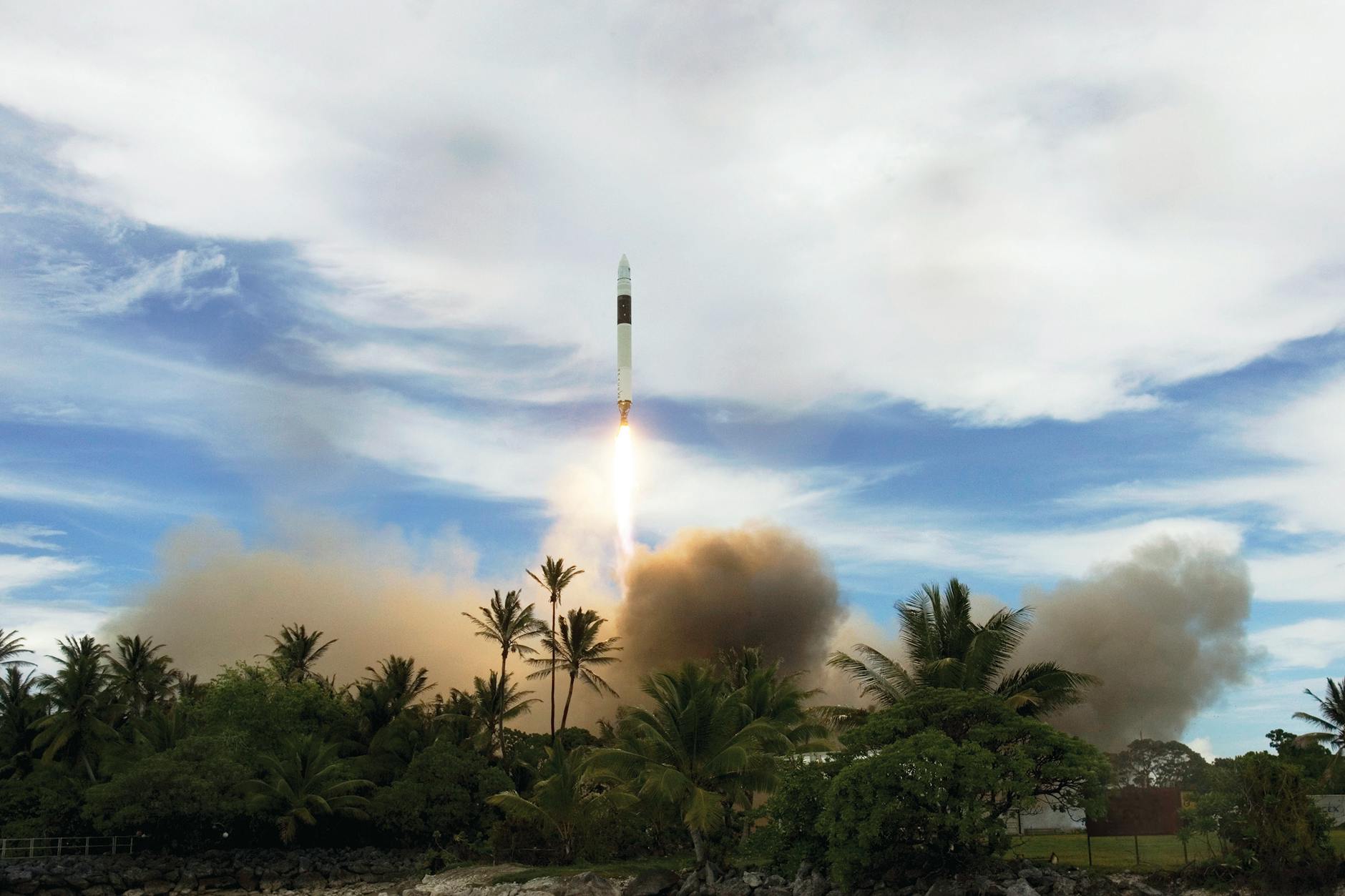 A dynamic rocket launch amidst lush tropical foliage and a clear sky, showcasing power and exploration.