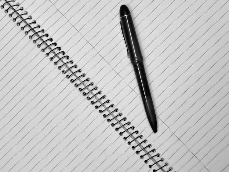 Diagonal Top View Of A Notebook with Lines And Black Pen