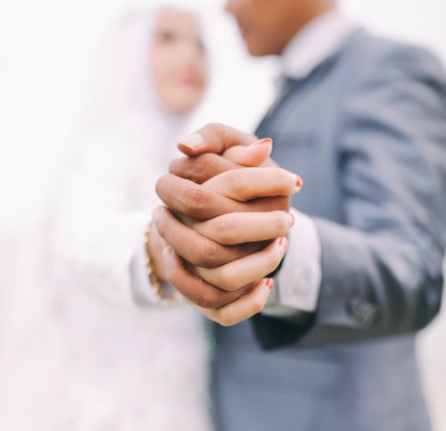 Free A close-up of a couple holding hands on their wedding day, symbolizing love and unity. Stock Photo