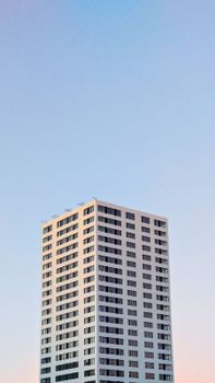 A tall modern skyscraper under a clear blue sky, showcasing contemporary architecture.