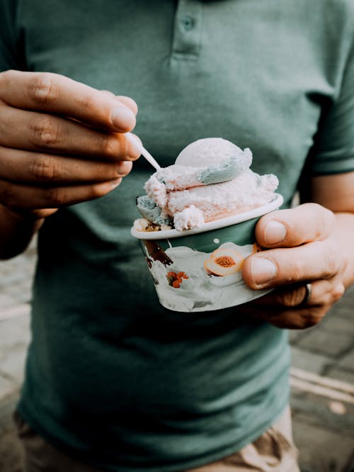 Orang Memegang Mangkuk Keramik Bunga Putih Dan Merah Muda Dengan Es Krim