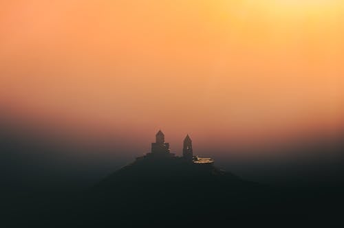 Silhouette of a Building on Top of the Mountain During Sunset