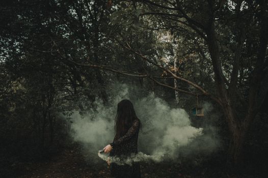 黑暗的森林中，一个神秘的女人被神秘的烟雾环绕