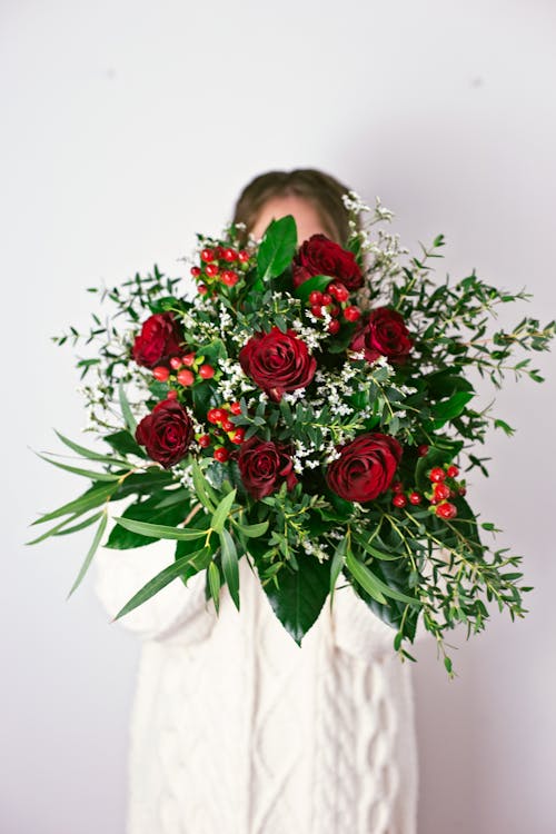 Free A Person Holding a Bouquet of Red Roses Stock Photo