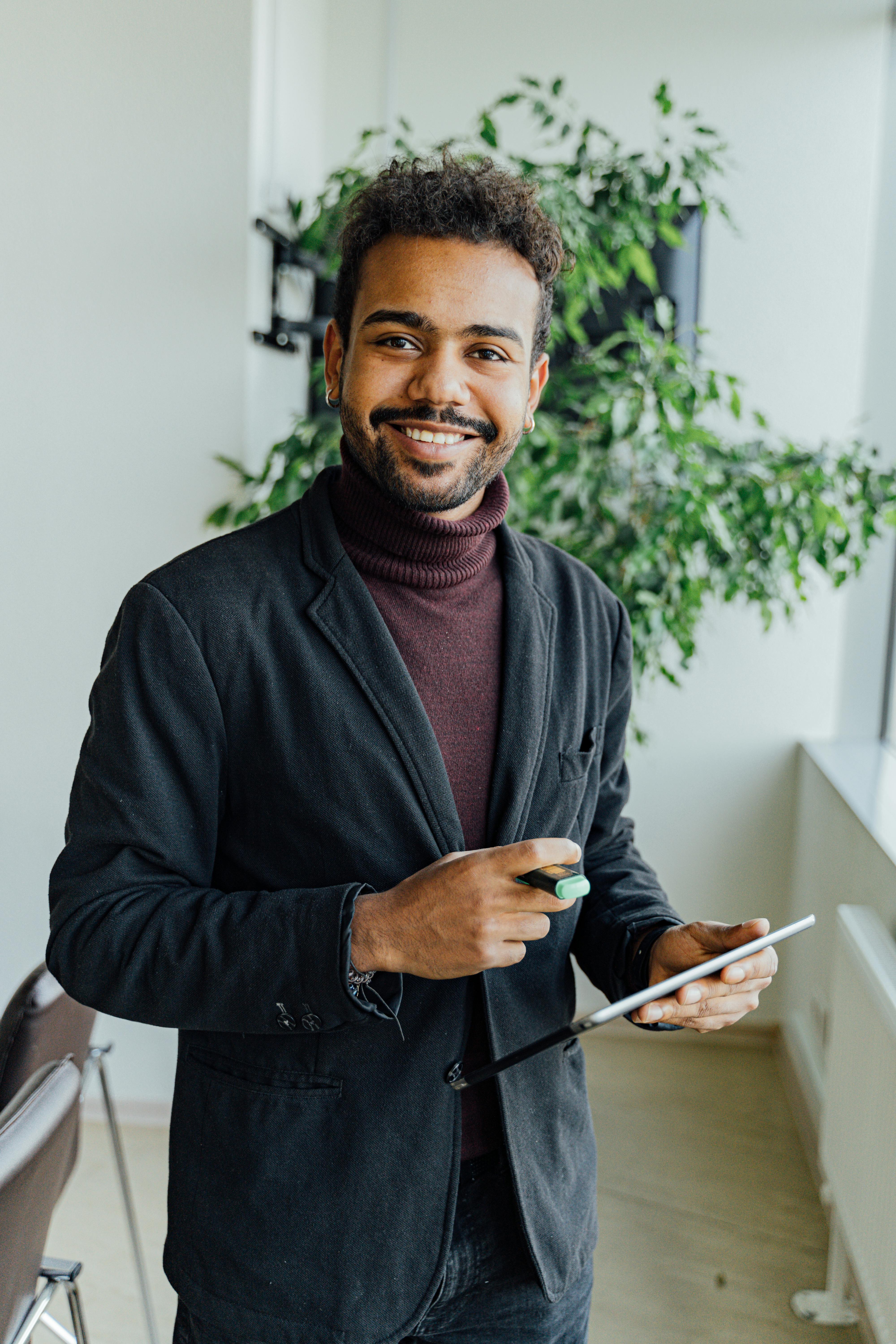 Man in Black Zip Up Jacket Holding Smartphone