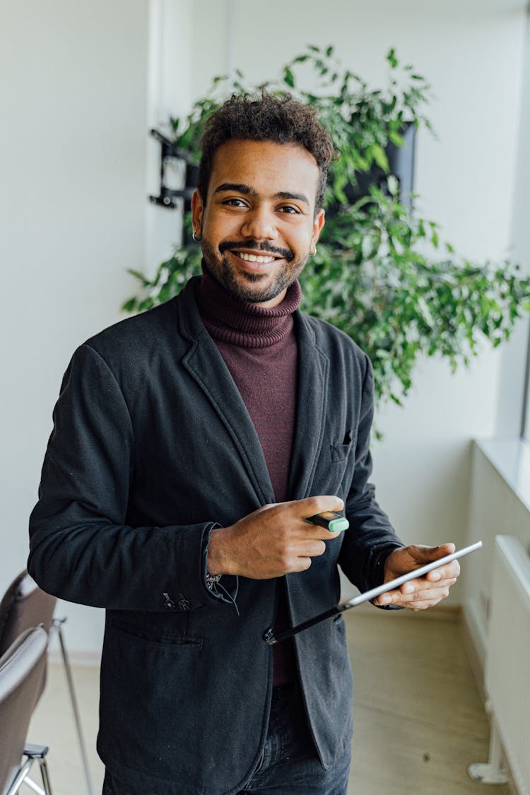 A Man In Black Suit Holding A Tablet