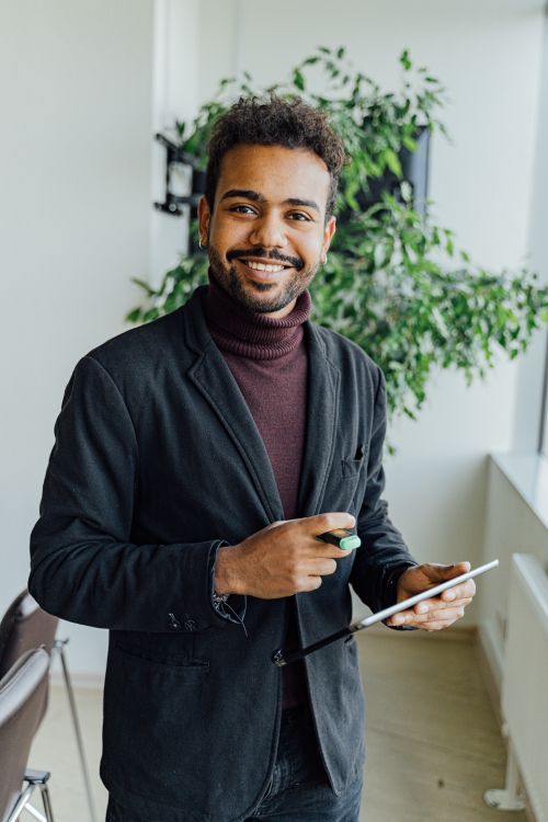 Free Confident professional using technology in a bright, modern office setting. Stock Photo