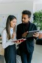 Man in Black Sweater Holding Ipad Beside Woman in White Cardigan