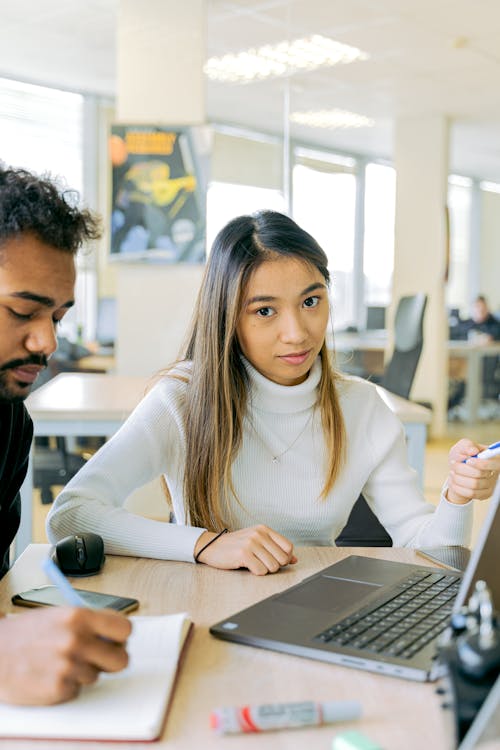 Woman in White Long Sleeve Shirt Using Macbook Pro