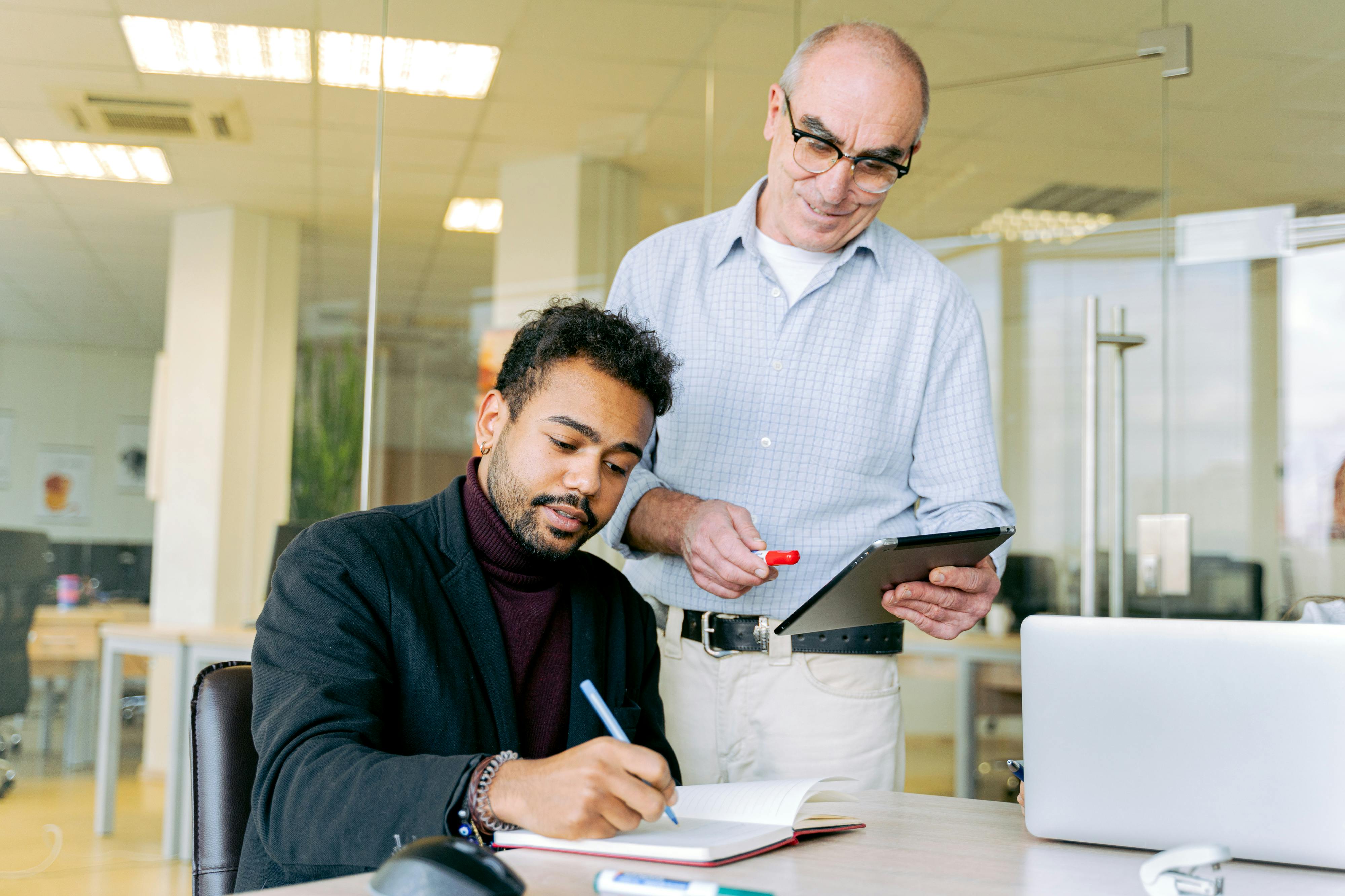 A professional interaction between two colleagues in a modern office environment, highlighting teamwork and communication.