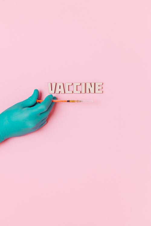 Vaccinentekst En Een Persoon Die Latexhandschoen Draagt Terwijl Hij Een Spuit Op Roze Achtergrond Vasthoudt