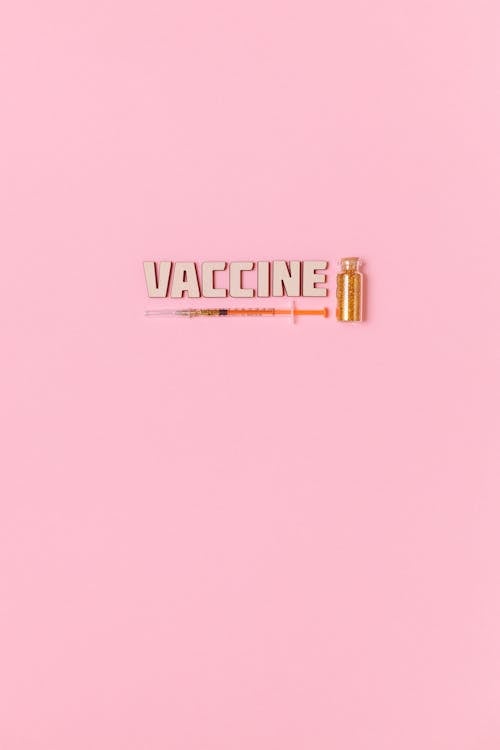 Teks Jarum Suntik Dan Vaksin Dengan Latar Belakang Merah Muda