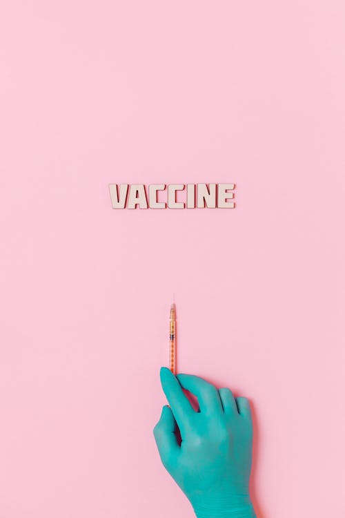 Vaccinentekst En Een Persoon Die Latexhandschoen Draagt Terwijl Hij Een Spuit Op Roze Achtergrond Vasthoudt