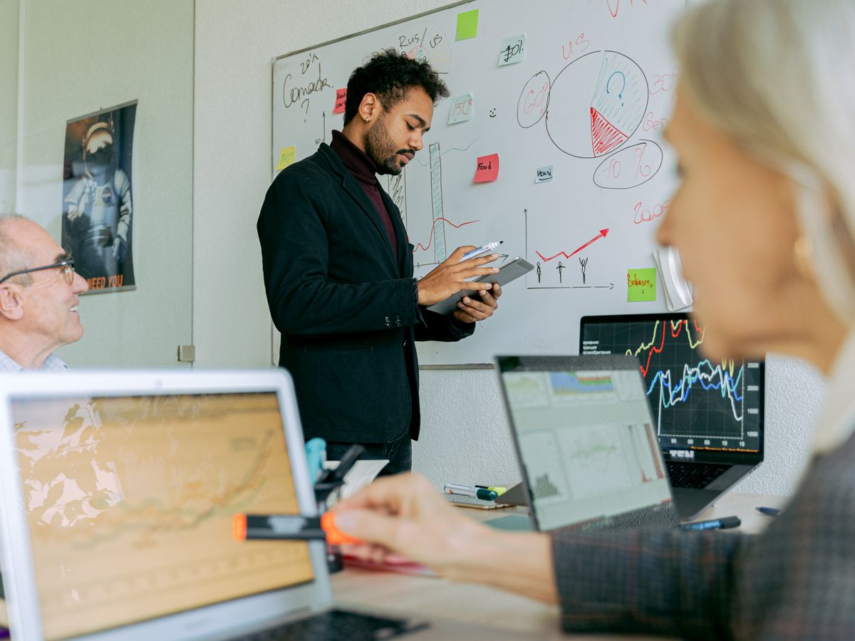 Technology leader presenting a plan to his team at a whiteboard