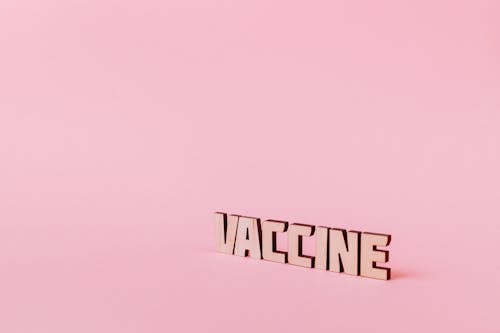 Free Vaccine Text on Pink Background Stock Photo