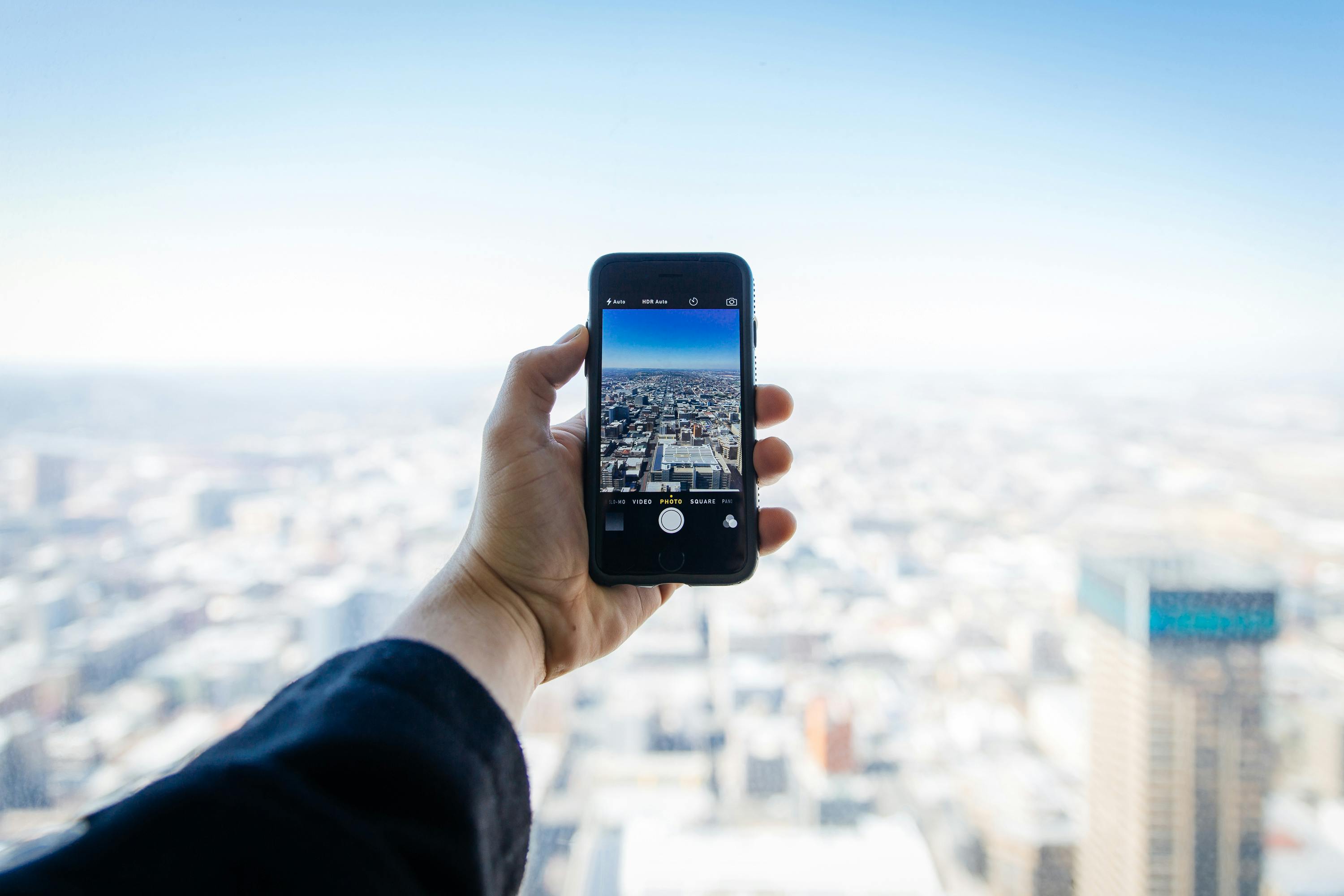 Man taking a photo of a city from a height.