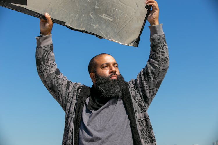 Man Holding A Block Above His Head 