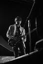 Monochrome Photo of a Man Playing an Electric Guitar Near a Microphone Stand