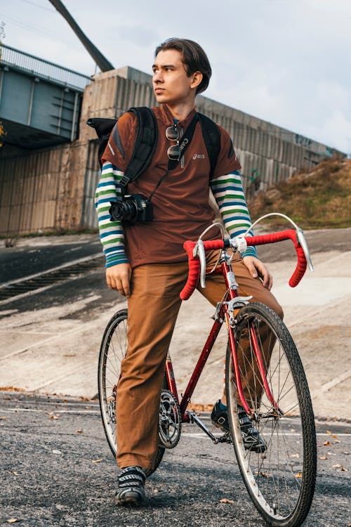 Photo of a Man Riding a Red Road Bike while Looking Away