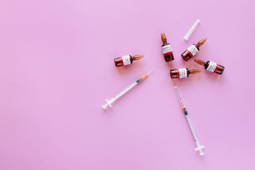 粉红色背景上展示着疫苗瓶和注射器，象征着医疗保健和免疫