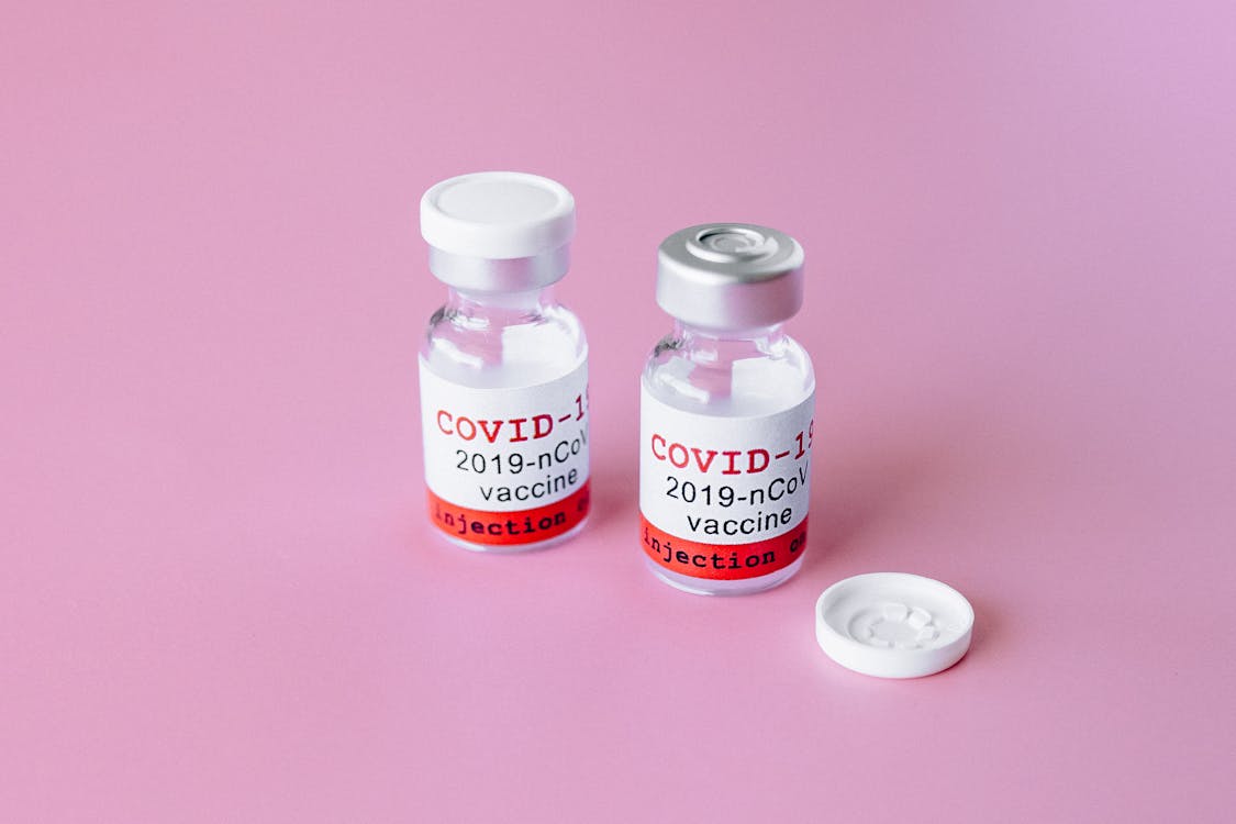 Two Covid Vials on Pink Surface