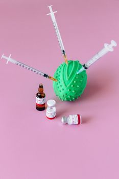 粉红色背景上排列着注射器和药瓶，上面有压力球
