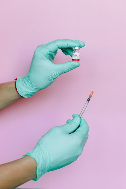 Person Covid Vaccine and Syringe
