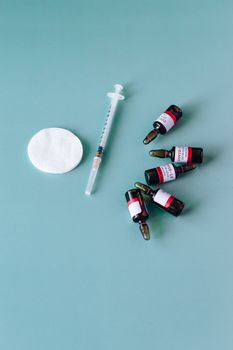青色背景的注射器和小瓶象征着医疗保健和疫苗接种