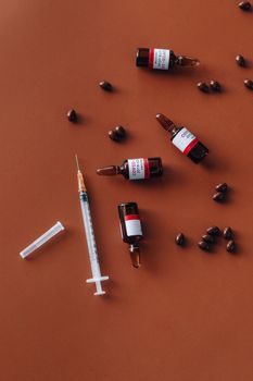 棕色表面上排列的注射器和药瓶的顶视图，象征着医疗保健