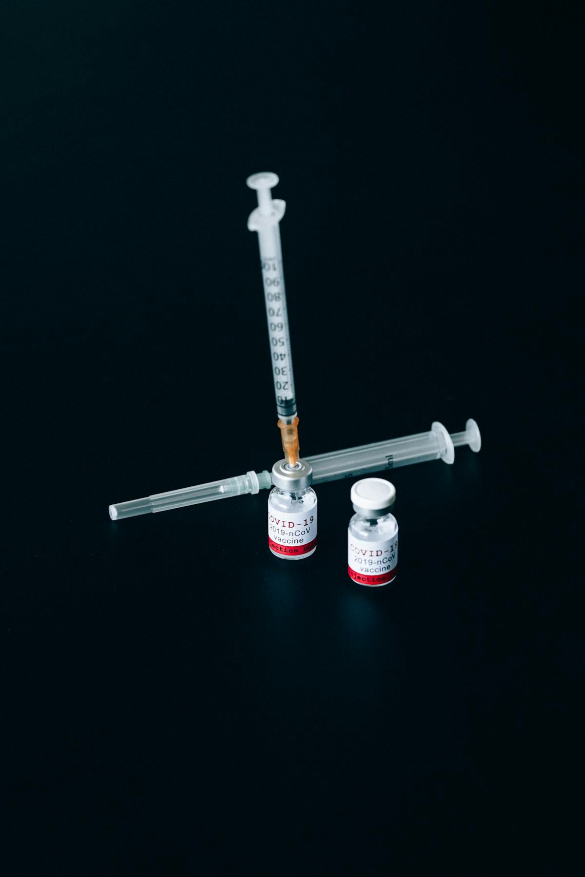 Nurse preparing a flu vaccine syringe beside a vaccine vial