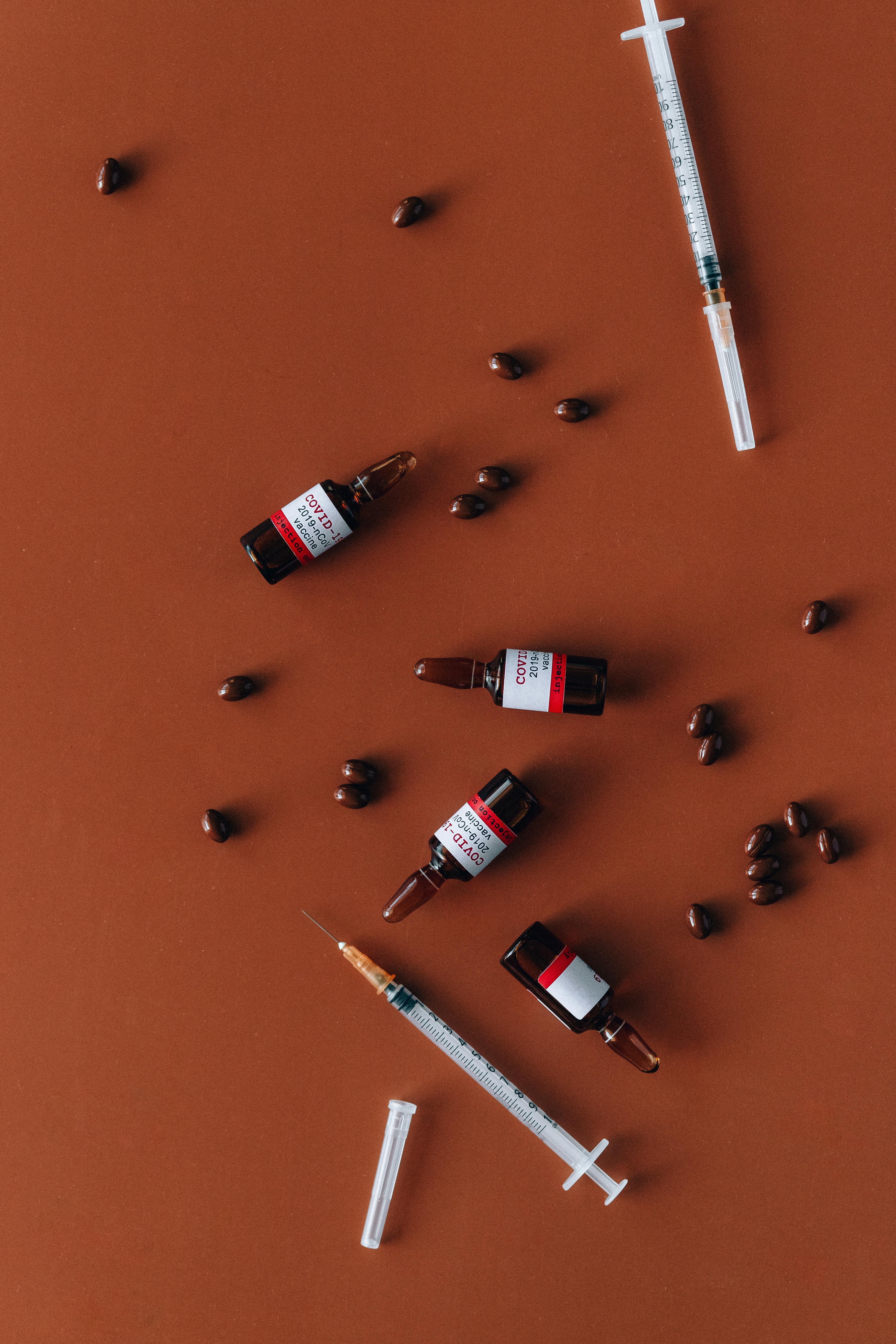tablets syringes and vials on red surface