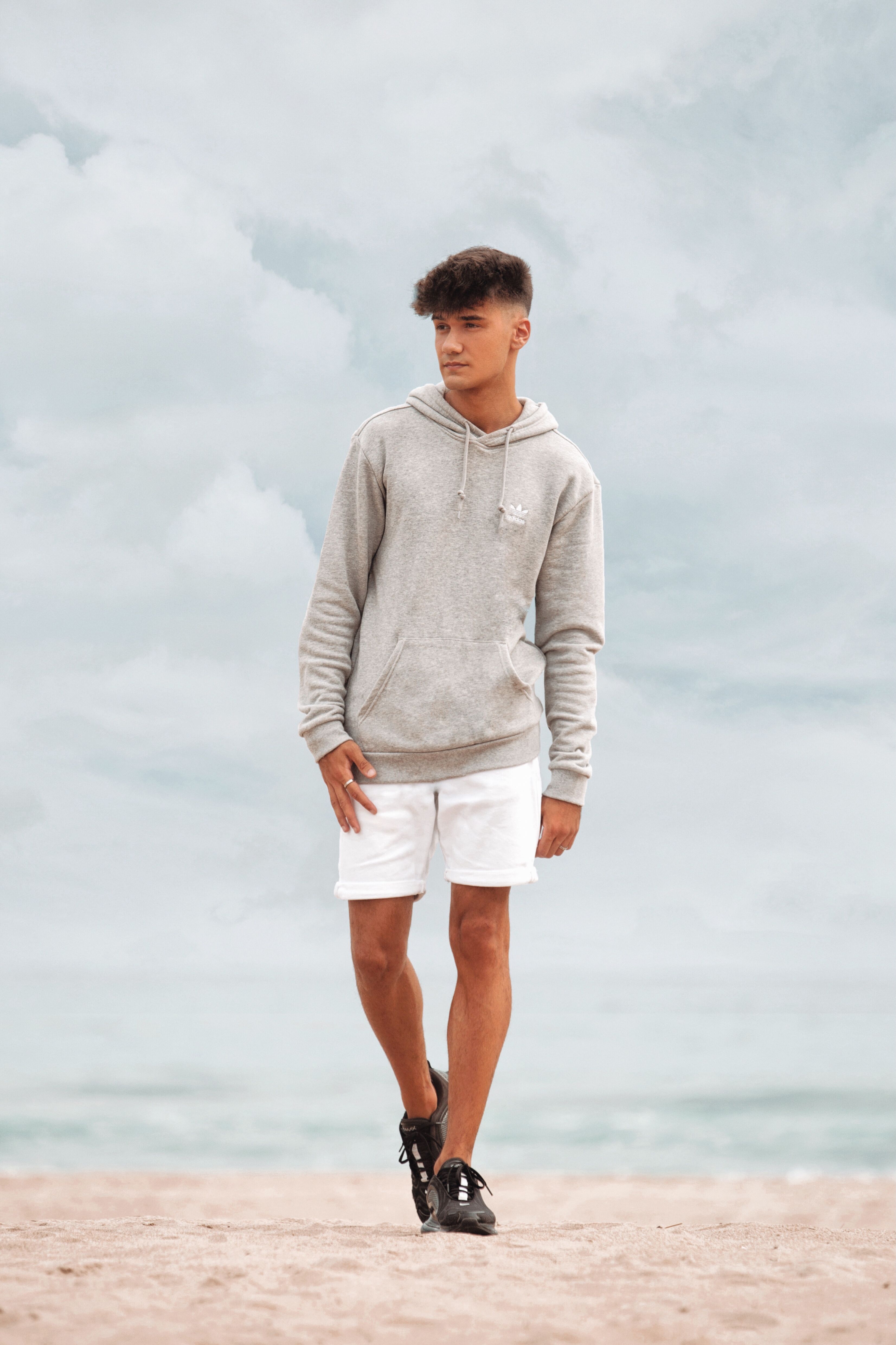 Photo of a Man in a Gray Hoodie Walking on the Sand · Free Stock Photo
