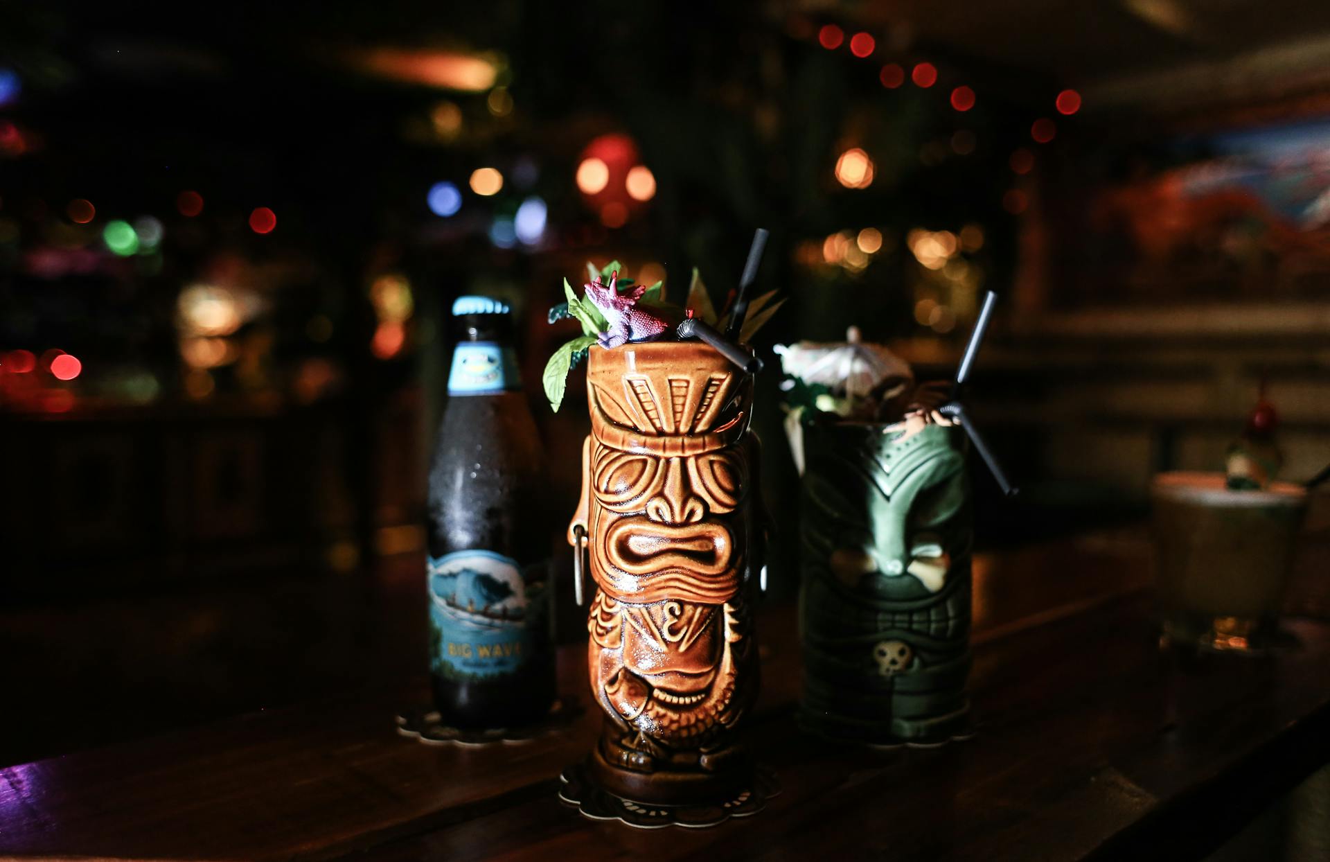 Vibrant tiki cocktails with bokeh lights in a cozy bar. Perfect for festive gatherings and exotic drinks.