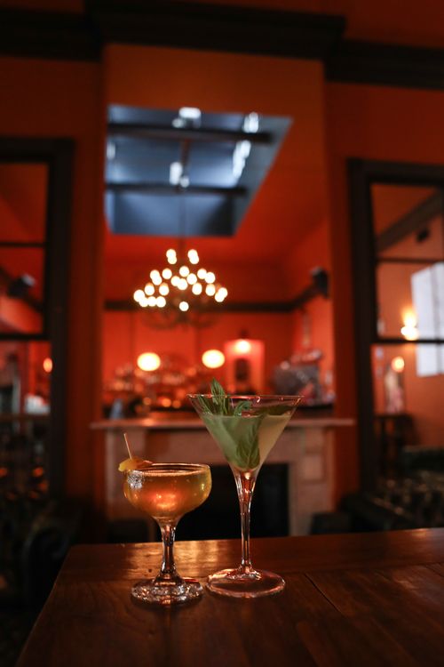 Free Two stylish cocktails on a wooden bar table in a warmly lit lounge setting. Stock Photo