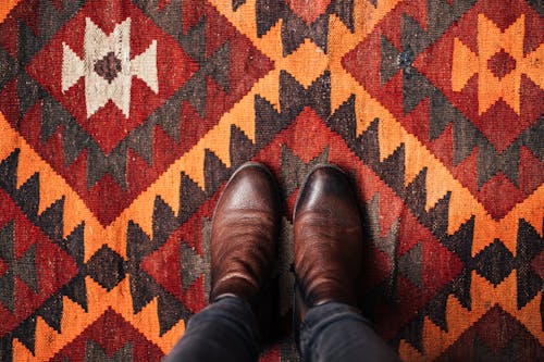 Free Person in Brown Leather Boots Standing on Rug Stock Photo