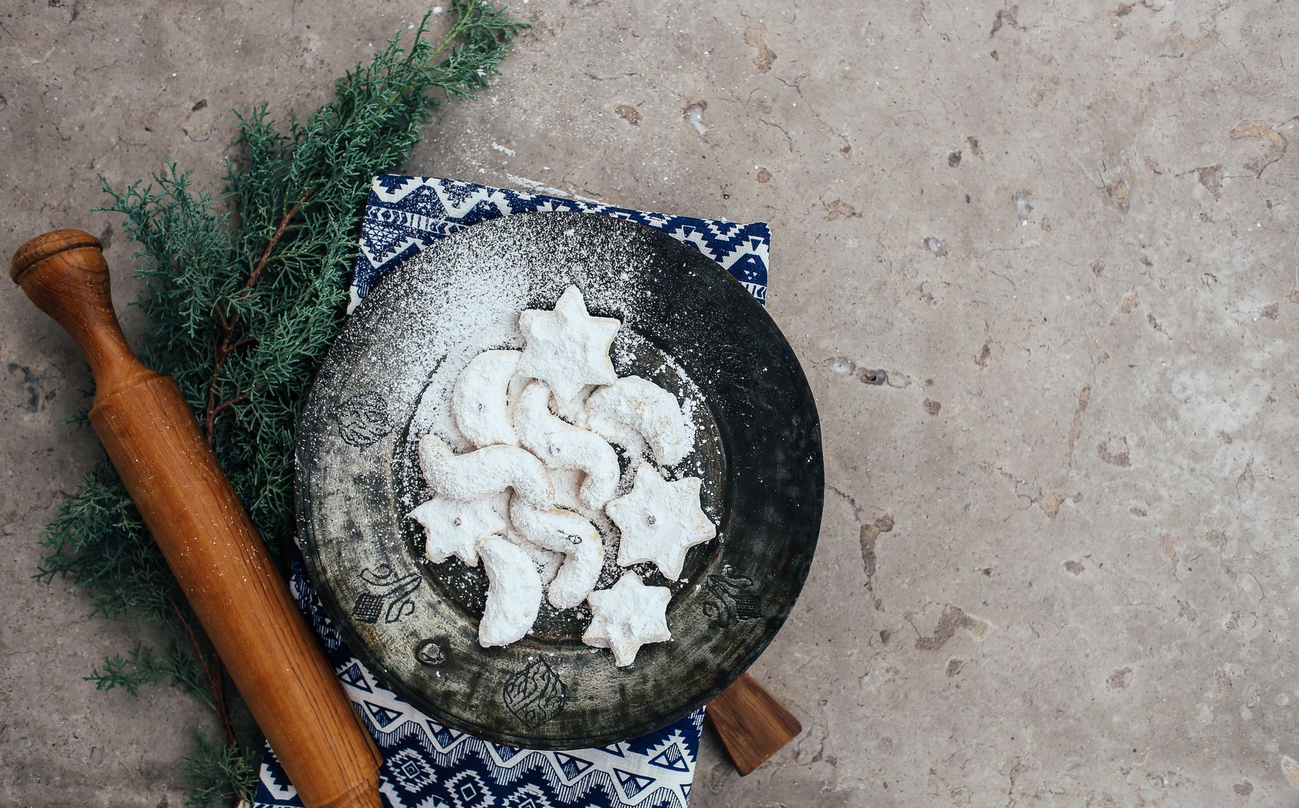 Almond crescent cookies dusted with powdered sugar on a wire rack